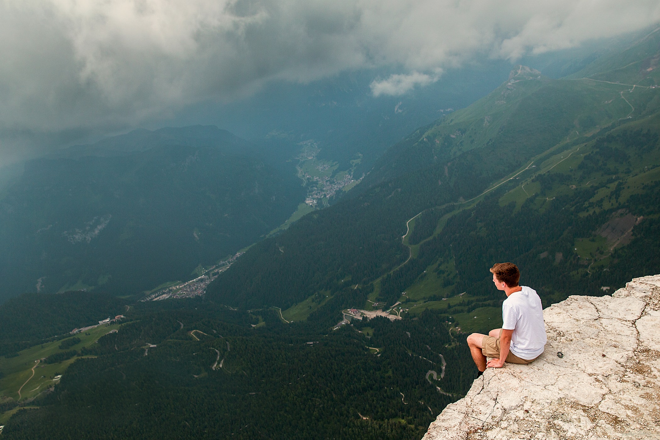 A photo of a man sitting on top of a mountain.
